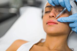 Woman receiving filler injection in her lips